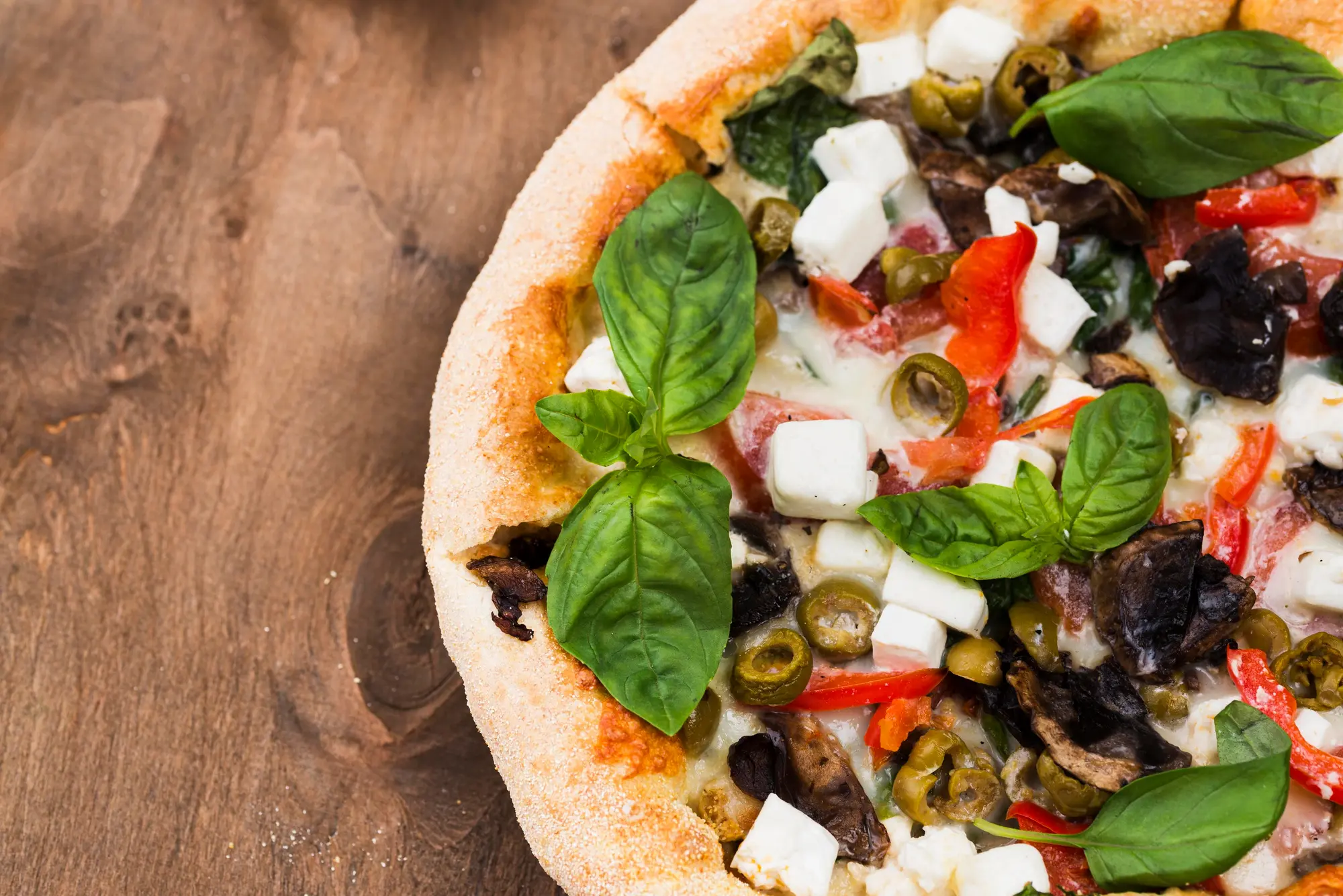 Pizza appena sfornata con pomodoro, mozzarella e basilico